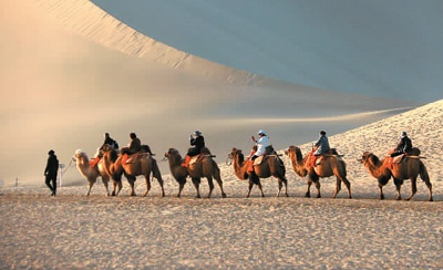 甘肃敦煌推出多项冬春季旅游优惠政策，吸引游客在冬春季节前来旅游。图为游客在鸣沙山月牙泉景区游览。张晓亮摄（人民图片）
