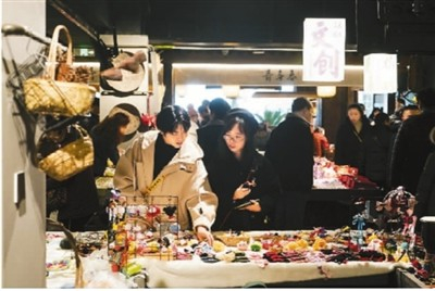 　　1月5日，年轻人在江苏苏州双塔市集购物。2019年，该市集经过升级改造后焕然一新，成为网红打卡地。　新华社记者 季春鹏摄