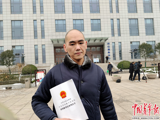 1月13日，张志超手拿再审判决书走出淄博市中级人民法院。