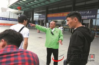 ▲徐觉非在火车站为旅客指路 记者 陈栋 摄