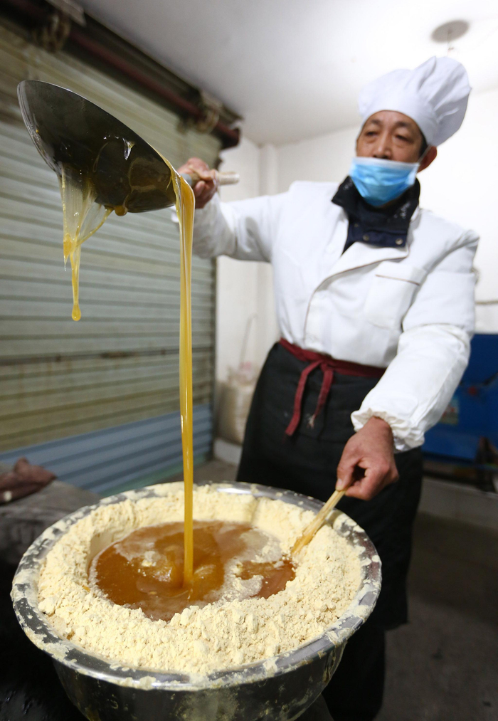 金惠民正在用麦芽糖稀和黄豆粉。受访者供图