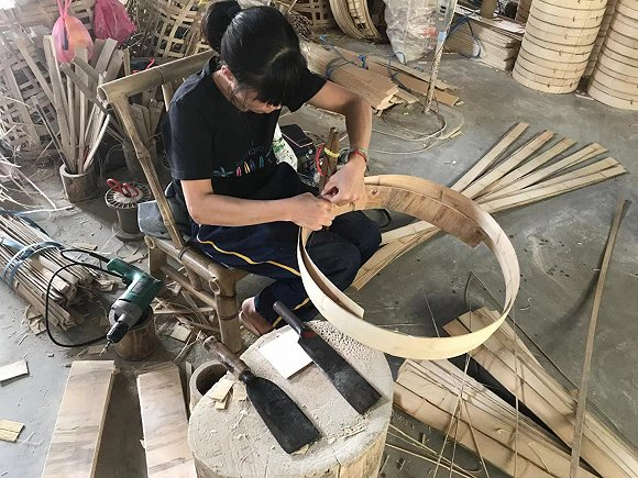 家庭作坊内，工人正在制作蒸笼。