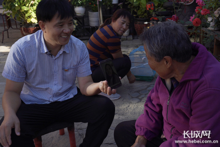 　　黄文忠打开视频通话，邀请唐宗秀在浙江打工的女儿常回家看看。 长城网记者 胥文燕 摄