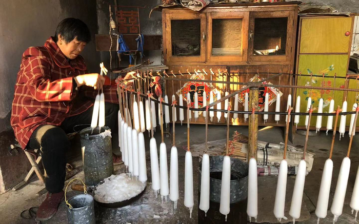 韩淑美在给蜡烛蘸蜡油。新京报记者 张羽 摄