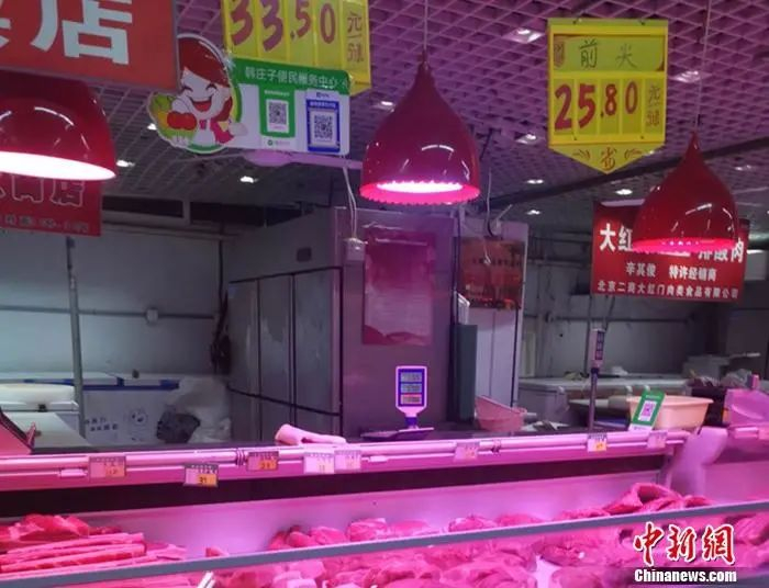 图为北京丰台区一家菜市场内的猪肉摊。谢艺观 摄