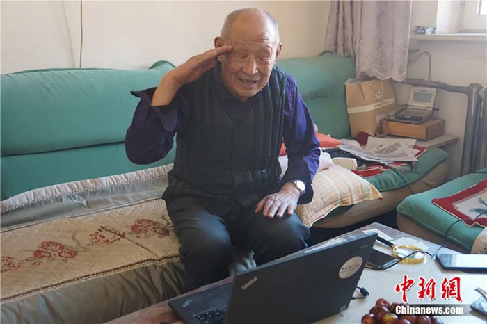 图为齐振荣与赵国珍通过视频隔空敬礼。乌娅娜 摄