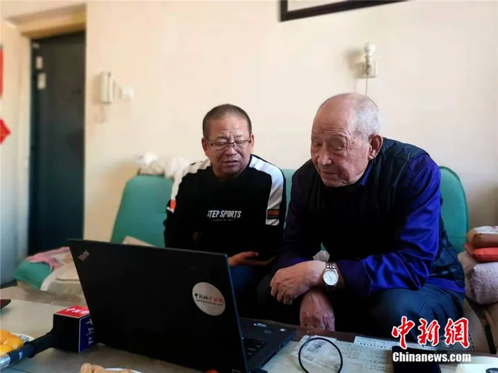 图为齐振荣老人和儿子齐正海与老战友视频通话。乌娅娜 摄