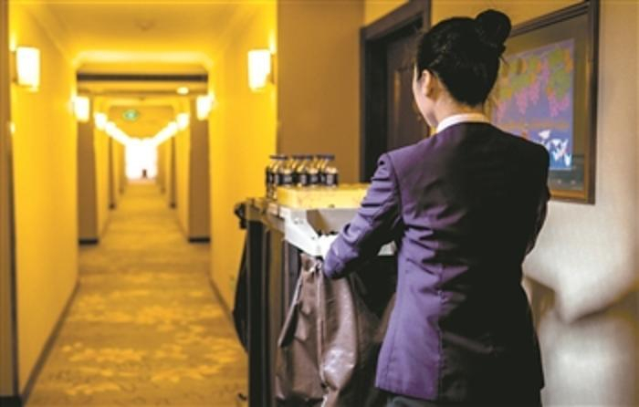 某五星级酒店房间保洁员推着工作车赶往下一间客房。 李润钊 摄