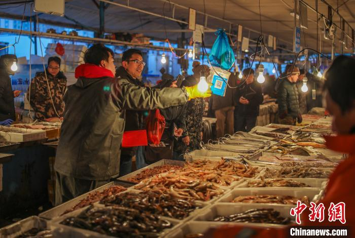 水产摊前人头攒动。　李信君　摄