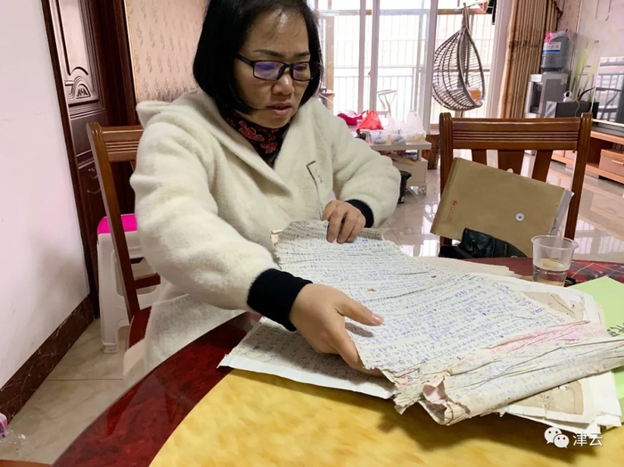 黄庆安翻着哥哥狱中写在卫生纸中的信&nbsp; 本文图片均来自“津云”微信公众号