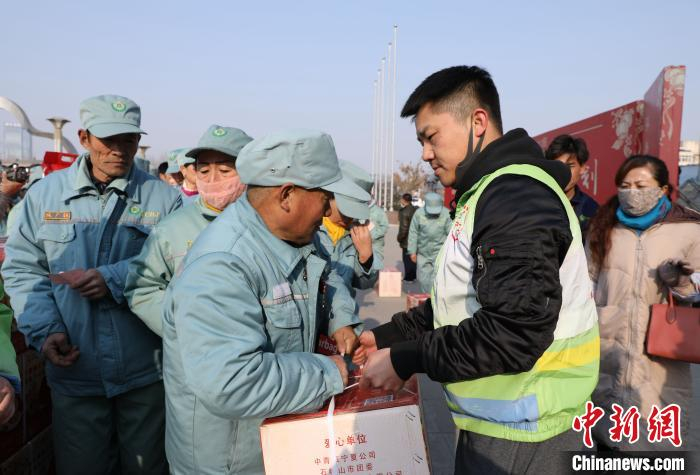 义工为困难家庭代表发放“雷锋饺子”爱心礼包。　杨迪 摄