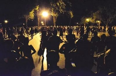  夜色下跳广场舞的大爷大妈们。