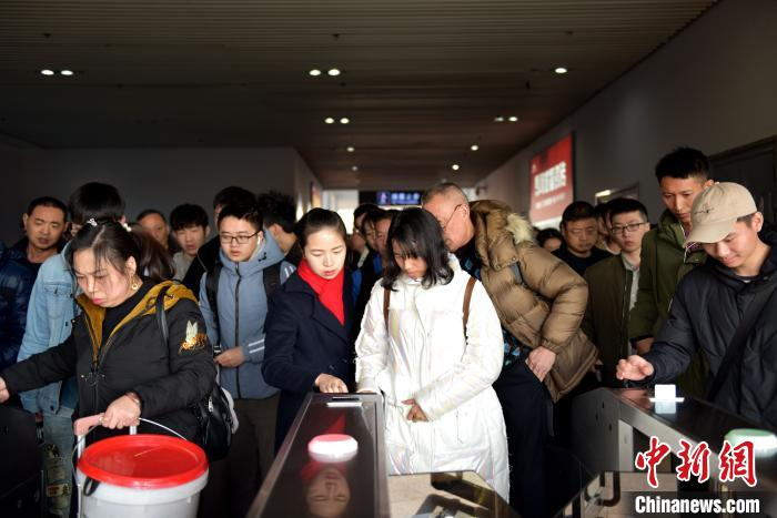 申时：胡兰在出站口协助旅客快速出站。　宋曹梓瀚 摄