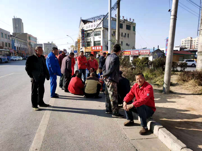 在公路转盘处等待干活的农民工。 《等深线》记者 倪兆中 摄