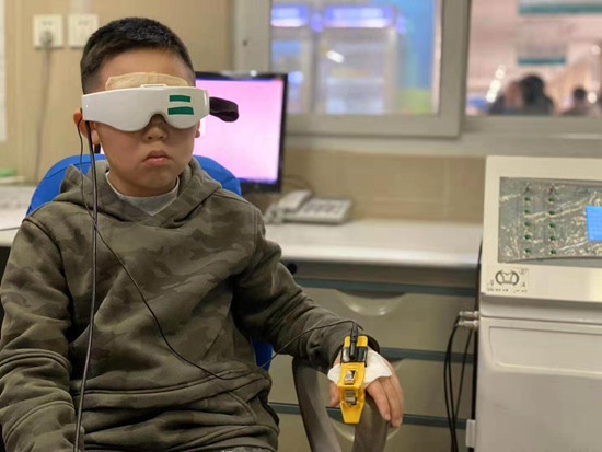  一名近视患儿遵医嘱在治疗室接受离子导入、低频脉冲、热敷治疗，缓解视疲劳，控制近视度数增长。（中国中医科学院眼科医院供图）