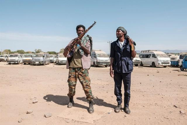 民兵在埃塞俄比亚军队北方司令部第5营的入口处摆好姿势（来源：法新社）