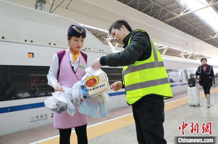 马涛正在将快餐交给列车员。　张杰 摄