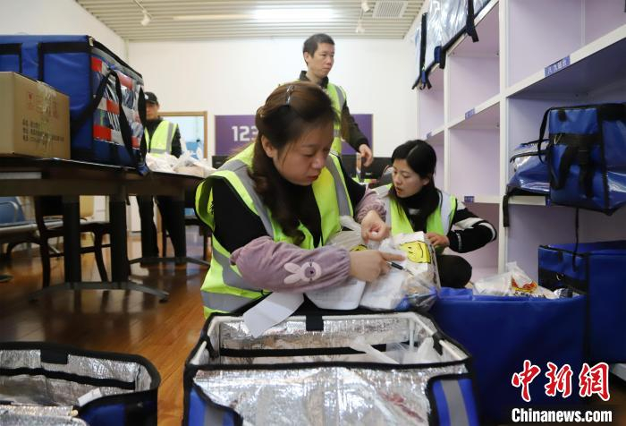 南昌西站配送中心的工作人员正在将快餐分车次放进配送箱。　张杰 摄