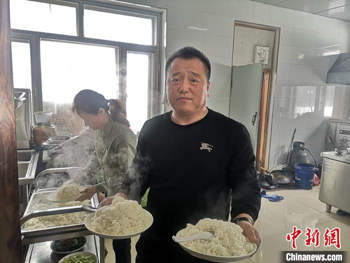 谢洪志正准备给客人上食物 石洪宇 摄