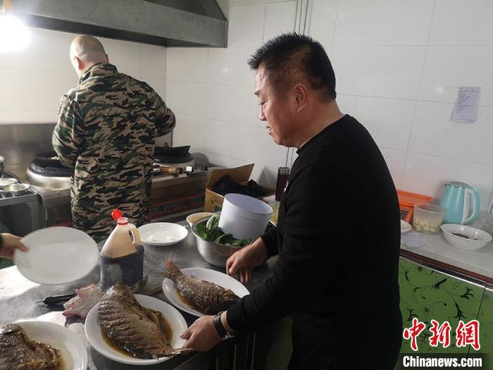 谢洪志在后厨帮忙 石洪宇 摄
