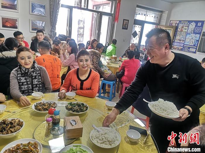 谢洪志正在给客人上菜 石洪宇 摄