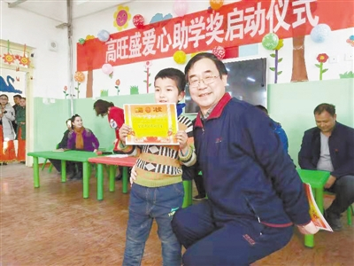  高旺盛（前排右一）在新疆墨玉县吐扎克其村幼儿园向小朋友发放助学奖 高旺盛供图 