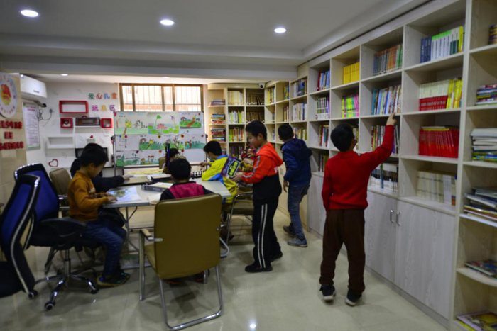 图为孩子们在于都县上欧思源安置点社区图书室借阅图书