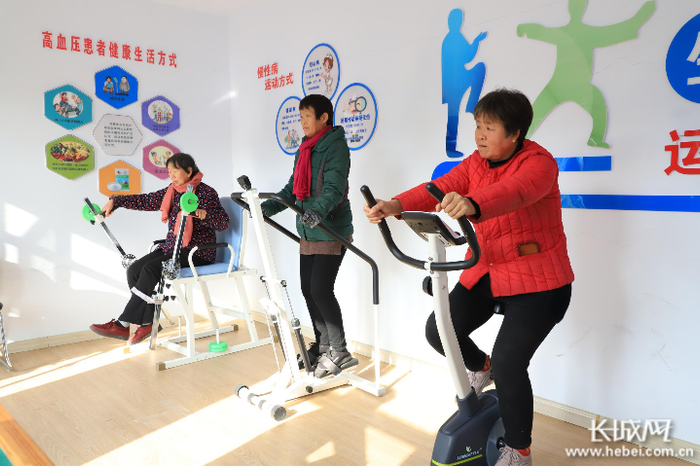 老人们在卫生院的健身器材上锻炼身体。通讯员 赵哲 摄