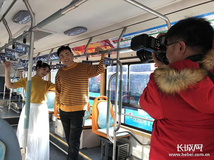 贾镇和胡启帆在公交车上拍摄婚纱照