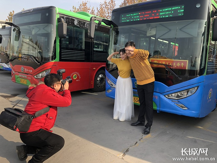 贾镇和胡启帆在公交车前拍摄婚纱照