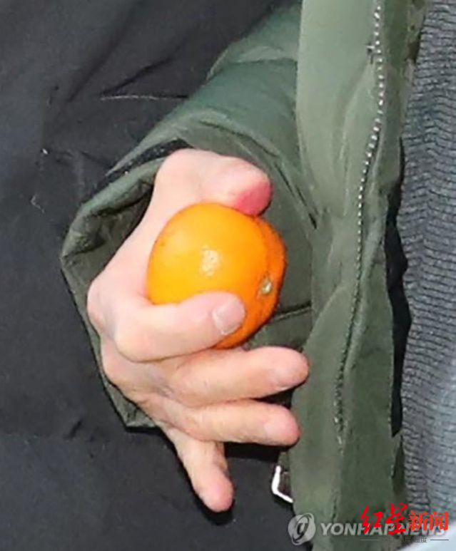 ▲赵斗顺进入守法支援中心时手里拿着橘子&nbsp;图据韩联社