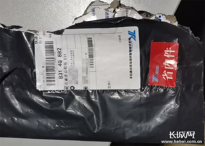 李先生遭破损的装有档案材料的快递袋。