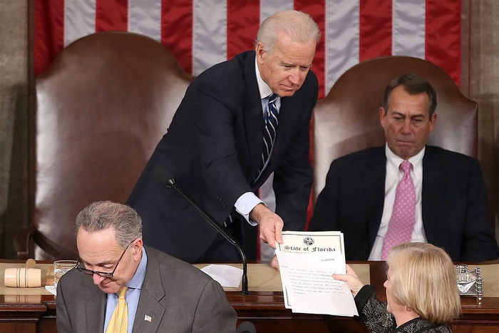 　　↑2013年1月4日，国会联合会议上，时任副总统、参议院议长拜登将选举人团投票证书交给密歇根州共和党众议员坎迪斯·米勒 图据NBC新闻