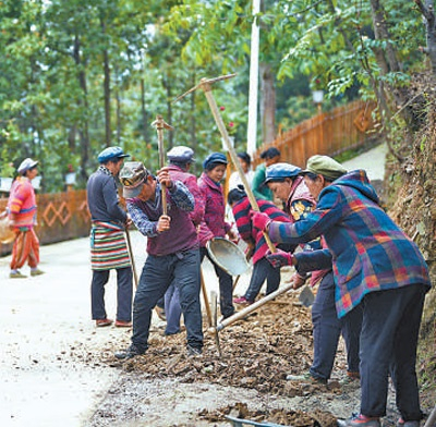 　　村民在路边建设村里的小花园。　　李建生摄 