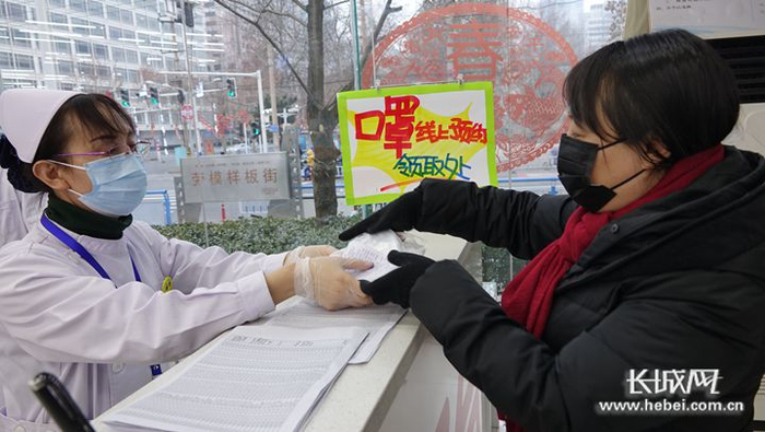 国药乐仁堂连锁药店青园街总店工作人员将口罩递给顾客。长城网记者 吴新光 摄