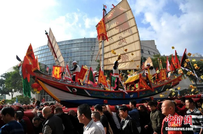  图为厦门海沧钟山送王船文化节，当地民众扛着王船游境。中新社记者 张斌 摄