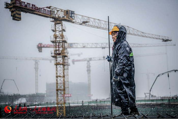 雪落时分依旧坚守岗位的建设者。任双欢/摄