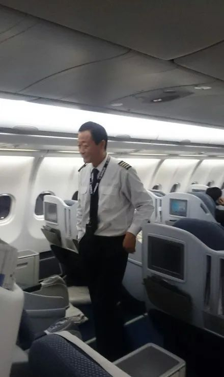 ▲ 贺机长面带笑意，在空荡荡的客舱内穿过。