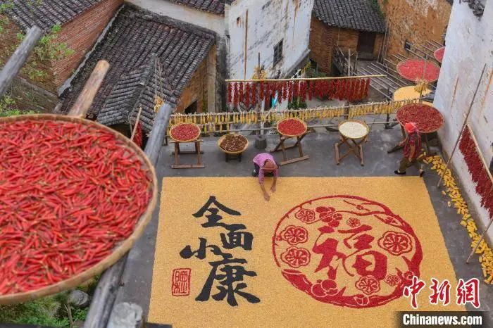 江西省上饶市婺源县篁岭村的村民们，用玉米、辣椒、大豆等农作物摆起了一幅“全面小康”的晒秋图，用最淳朴的方式来展现篁岭人在乡村旅游的助力下实现全面小康。（资料图）　方华彬　摄