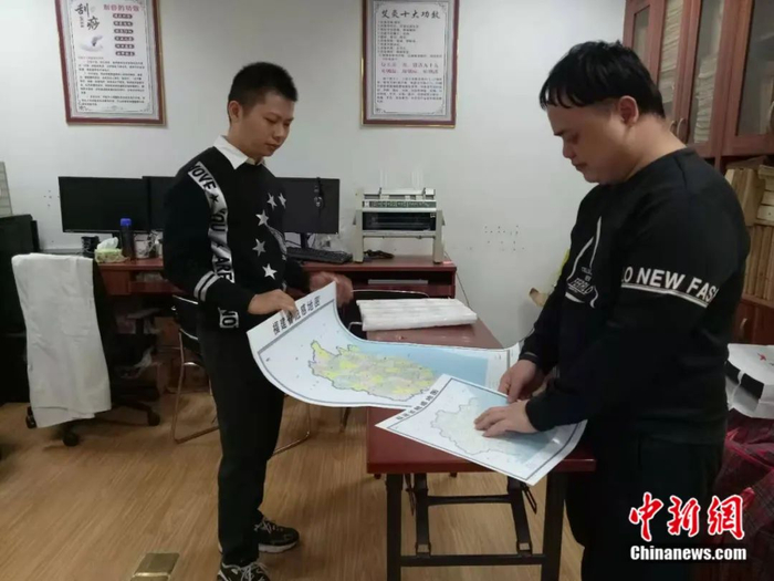 郭小明（右）负责地图盲文的校审。拿到这张地图，他比“想象的开心还开心”。郭兵 摄