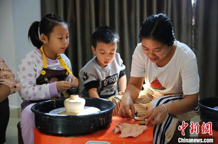 家长和学生共同完成陶艺课。　王晓斌 摄