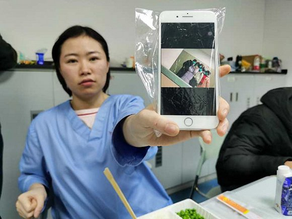 一名中南医院的护士展示科室里的同事合照。界面新闻记者 刘海川摄