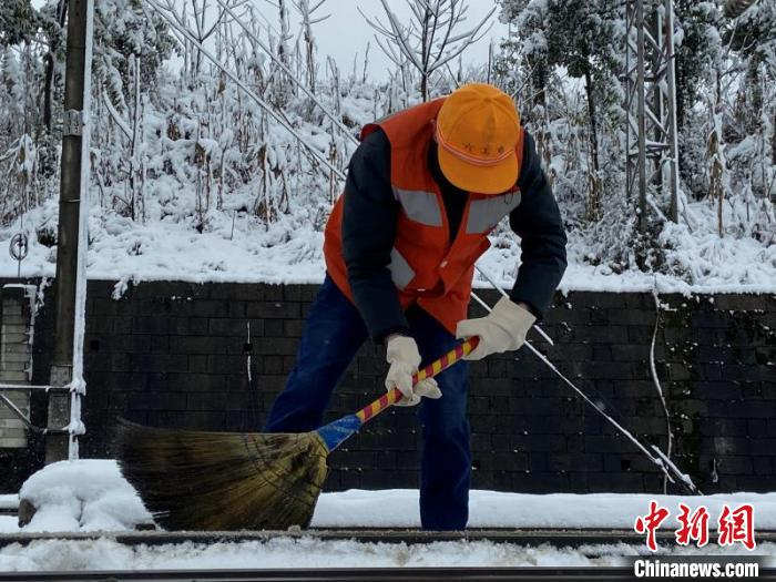图为中国铁路成都局集团公司六盘水工电段职工在清除铁路积雪。　丁卓 摄