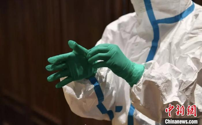 穿防护服的工作人员。　范方斌 摄