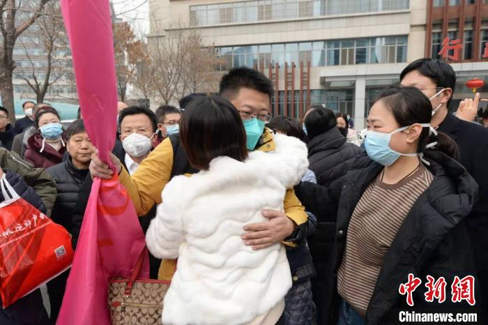 山西省抗击新型冠状肺炎紧急医疗队队员与家人拥抱告别。　胡静 摄