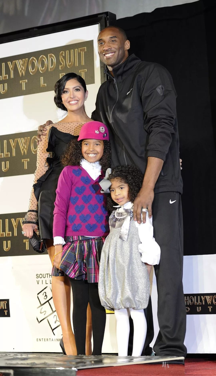 这是2011年2月19日，科比在美国加州好莱坞的中国剧院前广场留下手印和脚印后与和妻子儿女合影。新华社记者 戚恒 摄