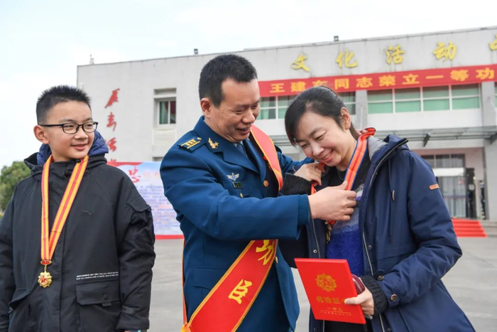 ▲军功章里也有你的一半，王建东给妻儿挂上军功章