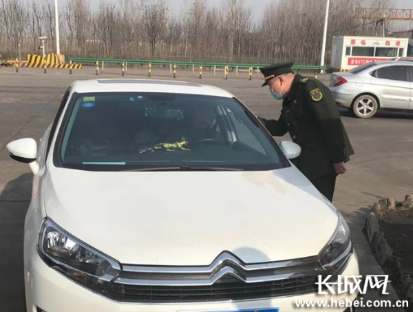 工作人员依次对进出站人员测量体温。王健 供图