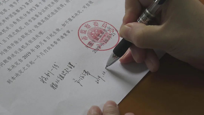 图为刘俊伟在政务处分决定书上签字。（黄星 摄）