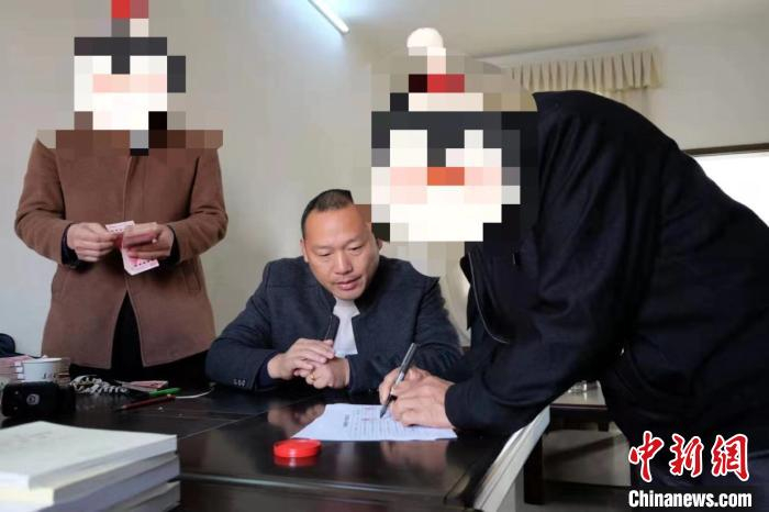 图为湖北省浠水县劳动保障监察局工作人员向农民工发放被拖欠工资 湖北省公安厅供图